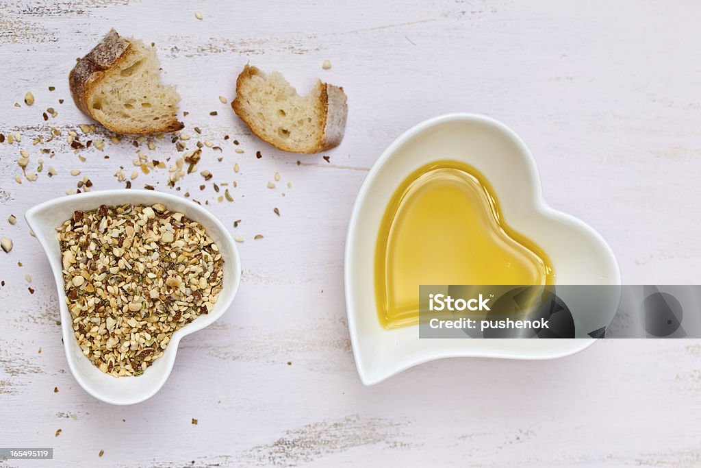 Dukkah con PAN y aceite de oliva en forma de corazón y tazones - Foto de stock de Aceite para cocinar libre de derechos