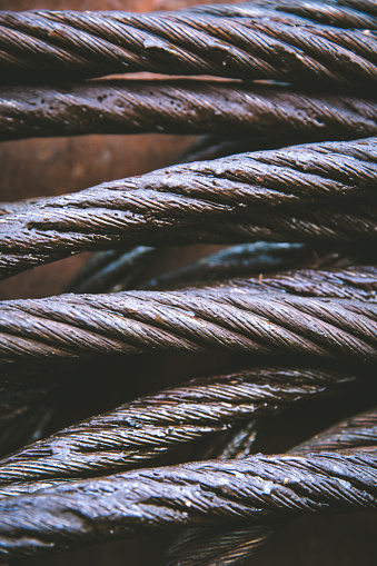 A full frame close up of strong metal cable used in shipping or construction that has been greased to protect from rust with copy space