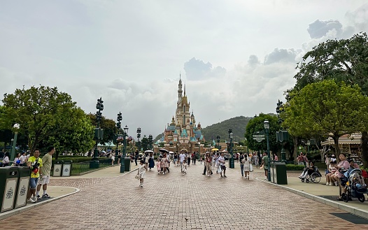 Paris, France - August 14, 2012: Image of the entrance in Disneyland Park from Paris. Tourists get into the park in morning, some take photo with the flowers.