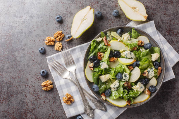 istock Blueberries, pear, leafy greens salad with walnuts and blue cheese close-up in a plate. horizontal top view 1654974214