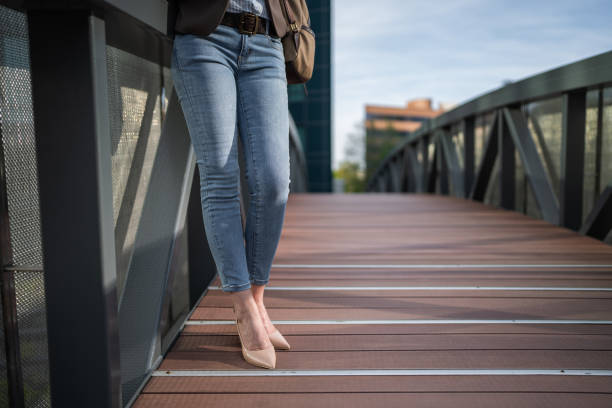 Unrecognizable modern mature businesswoman standing on a small bridge by the office building in city.
