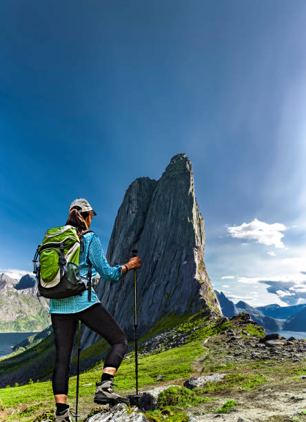 istock Woman with backpack in front of mountain peak Segla on Senja in Norway 1654986887