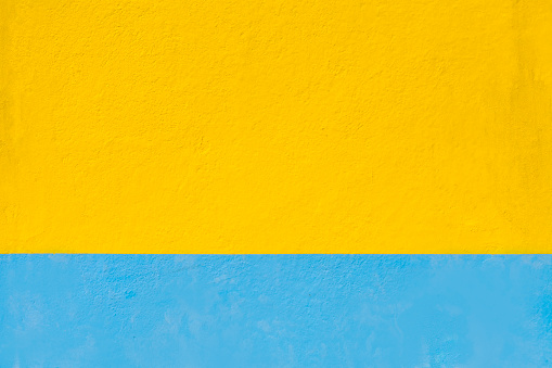 Wall painted yellow and blue baseboard , both available for copy space purposes. Ukrainian flag colors. Galicia, spain.