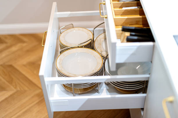 istock Open kitchen drawers with clean dishware and cutlery. Storage organization system in kitchen cabinets. 1655000460