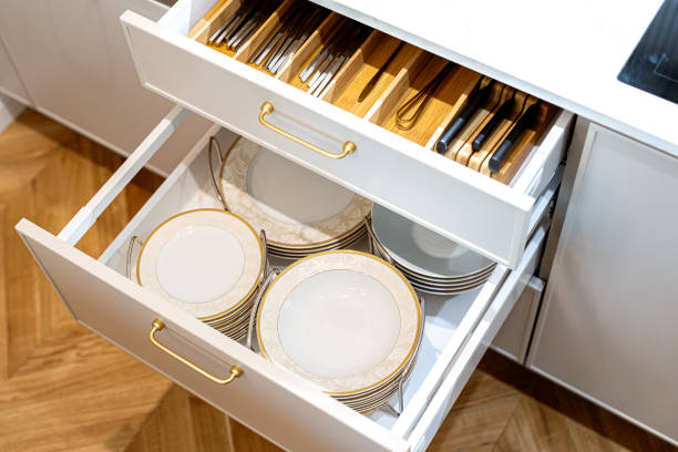 istock Open kitchen drawers with clean dishware and cutlery. Storage organization system in kitchen cabinets. 1655001982