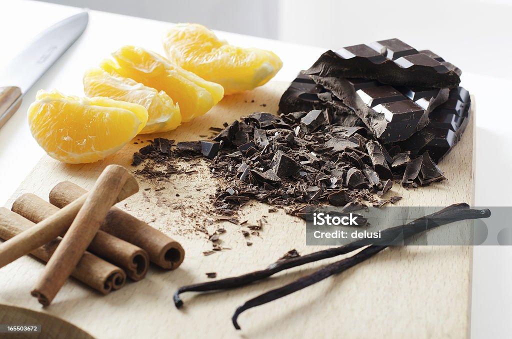 Orange chocolate vanilla and cinnamon prepared for dessert Orange chocolate vanilla and cinnamon on a chopping board prepared for dessert Chopping Food Stock Photo