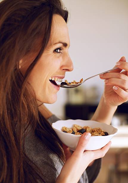 istock Smiling Woman Eating a Healthy Breakfast 165503961