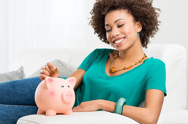 Photo of Woman Putting Coin In Piggybank