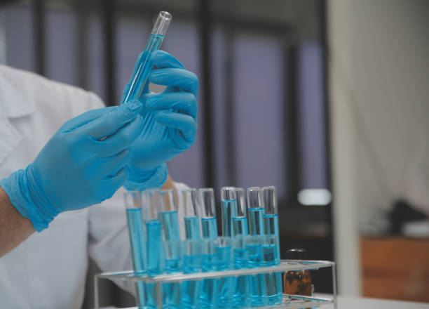 istock Scientist or medical in lab coat working in biotechnological laboratory, Microscope equipment for research with mixing reagents in glass flask in clinical laboratory. 1655079071