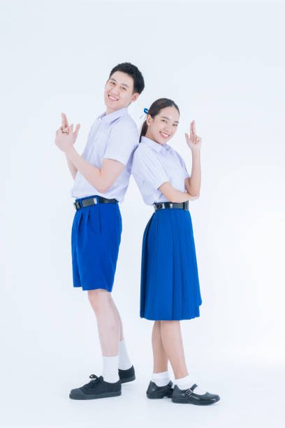istock Asian girl and boy in student's uniform on white background. Thai students. Two students having fun. 1655079240