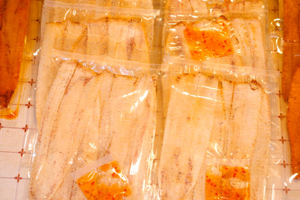 Dried flat rolled thai seafood snack in bags on market in Amphawa