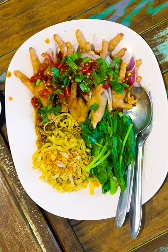 Plate with fresh thai noodles, vegetable and chicken feet