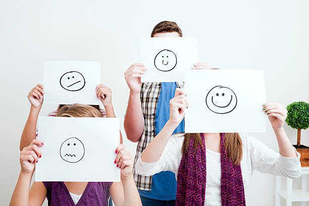 istock Young people holding cartoon faces in front of their faces 165510448