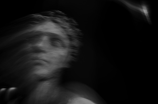 Portrait of an ancient Greek god from the period of antiquity. Motion blur in black and white