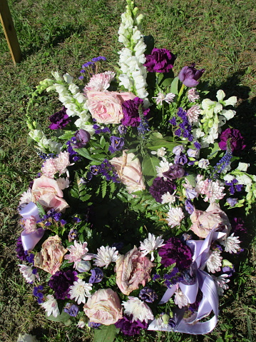 dying flowers in a funeral wreath on a grave in a cemetery