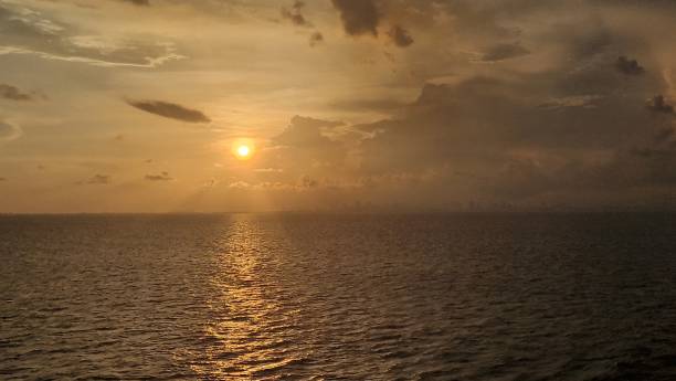 istock Wide angle golden sunset over ocean with dramatic clouds in blue sky September 2023 1655156723