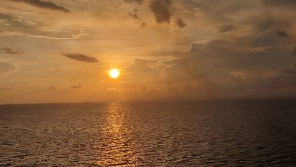 istock Wide angle golden sunset over ocean with dramatic clouds in blue sky September 2023 1655157247