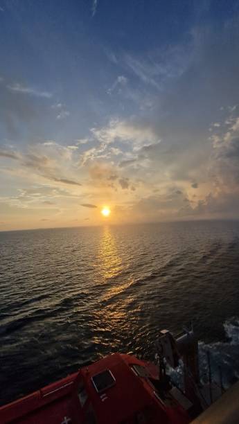 istock Wide angle golden sunset over ocean with dramatic clouds in blue sky September 2023 1655158805