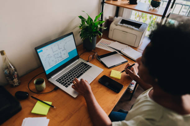 istock Mature woman using laptop and annotating at home 1655167477