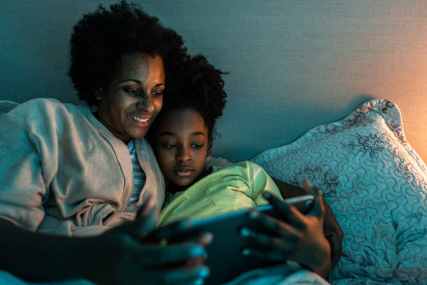istock Mother and daughter using digital tablet before sleep in the bedroom at home 1655174008