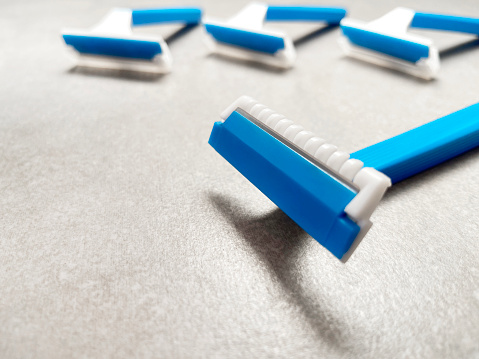 Razor blades. Blue shaver on the granite bathroom tile background. Group of plastic shaver with copy space