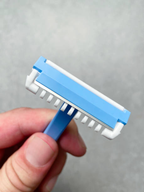 istock Hand holding razor blade. Hand holding blue shaver 1655175075