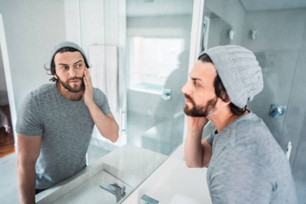 istock Mid adult man checking his beard in the bathroom's mirror 1655179800