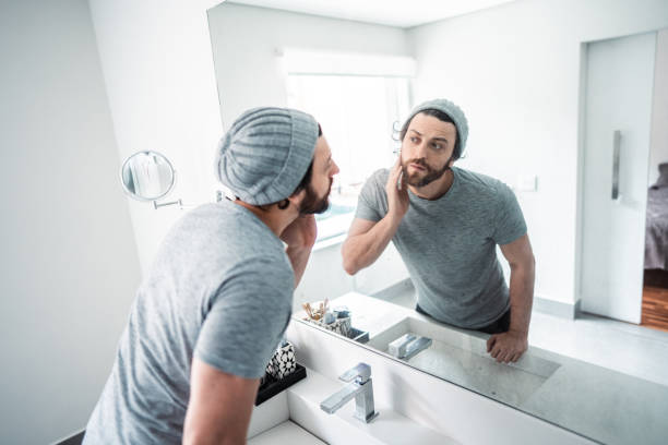 istock Mid adult man checking his beard in the bathroom's mirror 1655179801