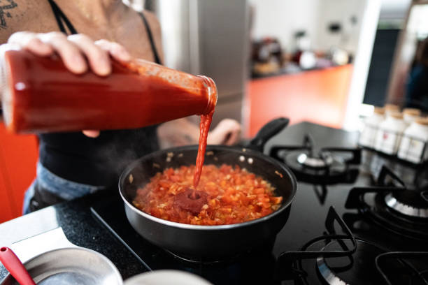 Mature woman preparing sauce at home