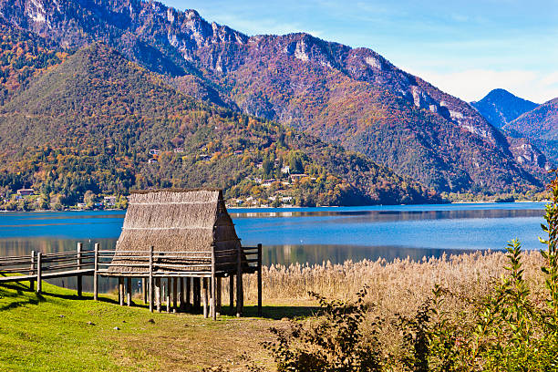 Stilt House At Lake Ledro, Italy This stilt house has been reconstructed on the banks of the Lake Ledro, in Trentino Alto Adige, in northern Italy. This beautiful lake is not only a natural attraction, but is also an archaeological site of global importance, thanks to the discovery of an extensive area of stilt houses dating to the Bronze Age. A museum has also been open to house the artifacts collected. Trentino Alto Adige, Italy.  stilt house stock pictures, royalty-free photos & images