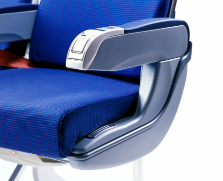 blue airplane seat on white background, selective focus on the foreground, shallow depth of field 