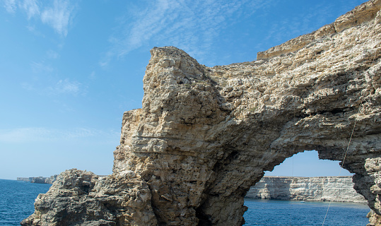 High rocks and dangerous cliffs. Azure Sea and Blue Sky. Crimea. Black Sea Coast