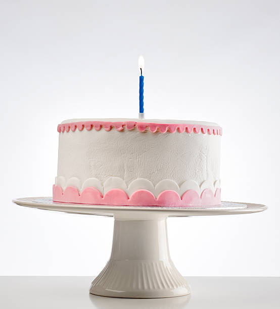 istock birthday cake on cakestand with one burning candle 165521430