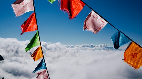 coloured flags in mountains above the clouds