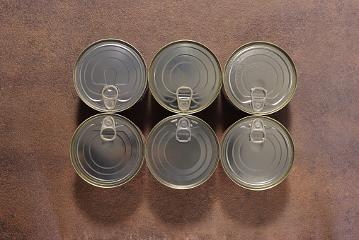 Image of a group of closed tin cans with a key to open them.