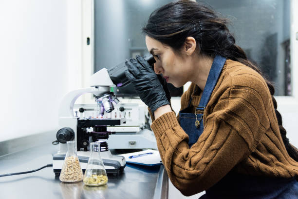 istock Mid adult woman using microscope in a laboratory 1655321579
