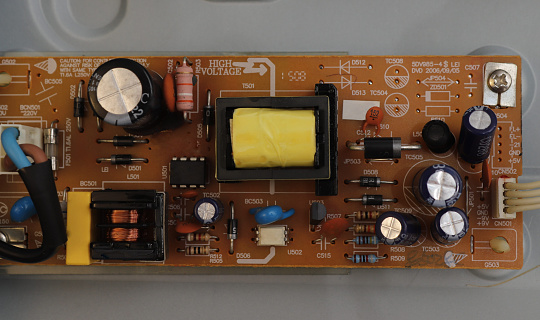 The board of a radio engineering device is shown with transistors, capacitors, resistances, diodes, transformers, chokes and other radio elements installed on it.