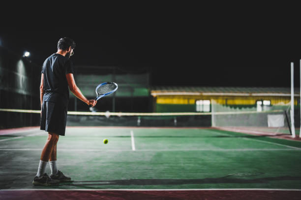 istock Man playing tennis at night 1655359546
