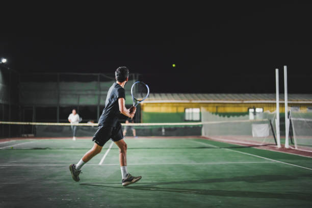 istock Man playing tennis at night 1655361654