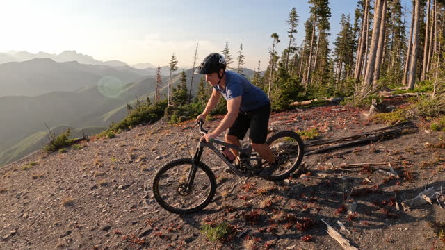 Male mountain biker descends steep slope