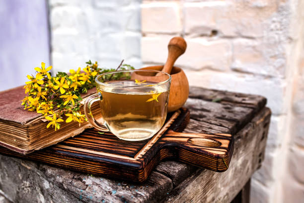 istock St. John's wort. Hypericum plants yellow flower medicinal tea from dry herbs or a drink from tincture of medicinal plants crushed in a mortar. Ancient recipes of alternative medicine medicines in old books. 1655370321
