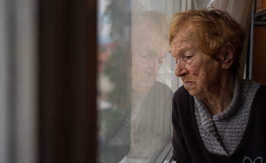 old woman looking out window