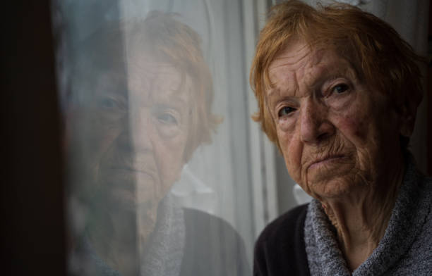 istock old woman looking out window 1655528417
