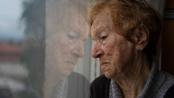 istock old woman looking out window 1655528444