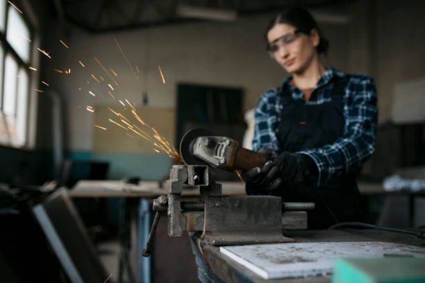 istock Female mechanical worker grinding a surface of workpiece with angle grinder on a workbench 1655563314