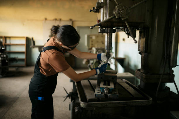 istock Young woman fitting a drill bit on drilling machine in workshop 1655568157
