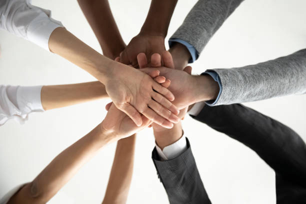 istock Close up of diverse colleagues join hands showing unity 1655568674