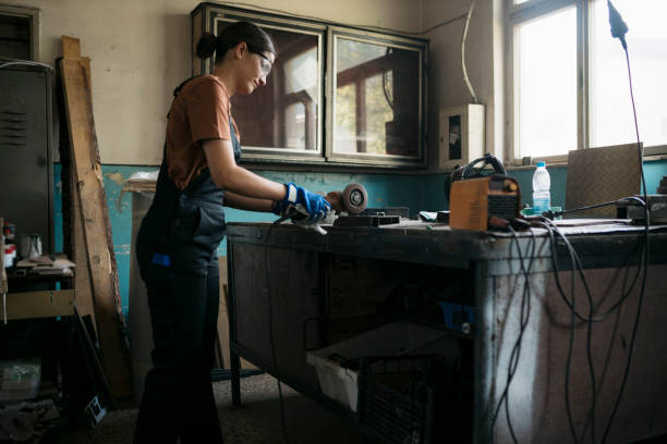 istock Woman worker cutting a metal pipe using angle grinder in workshop 1655574601