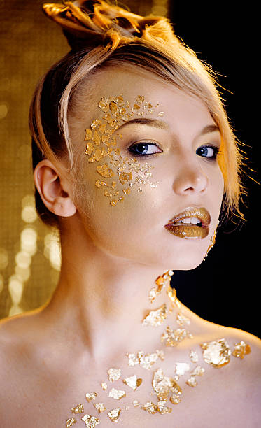 istock beauty blond woman with gold creative make up 165565877