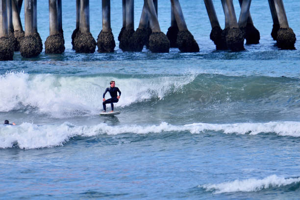 Surfer Leans into a Bottom Turn at Huntington Beach Pier
